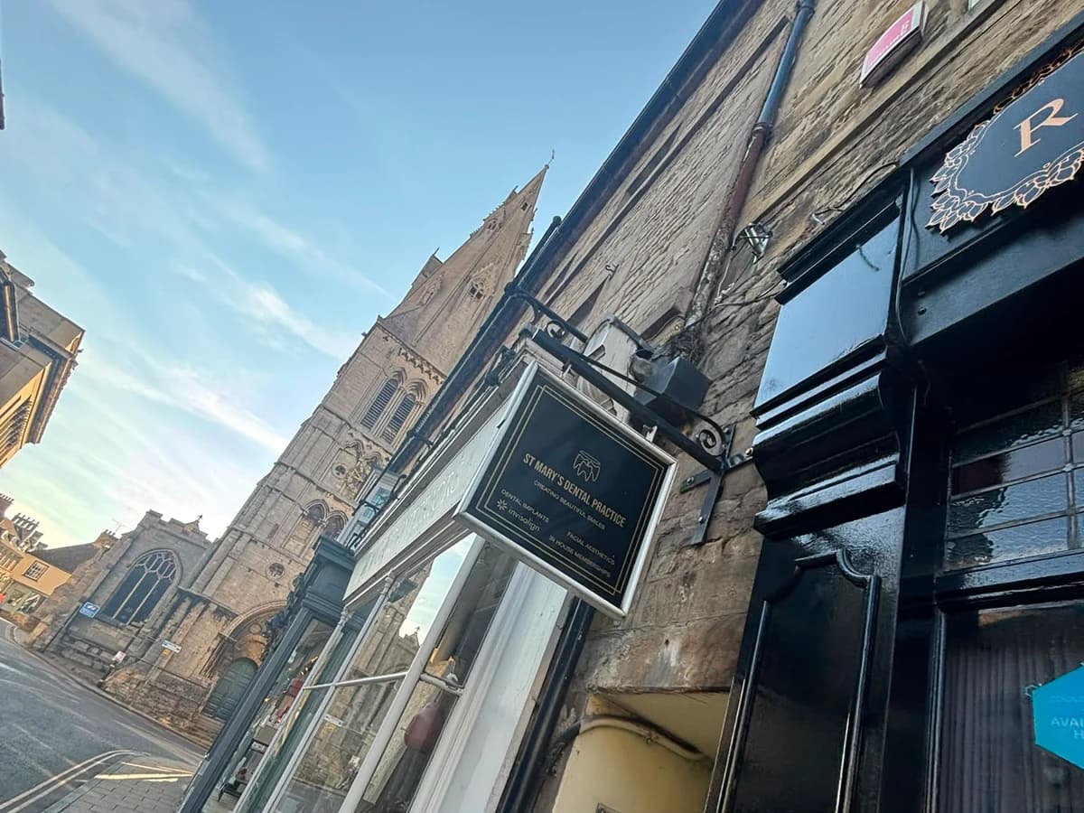 The St Mary's Dental Practice sign on St Mary's Street, with St Mary's Church behind it
